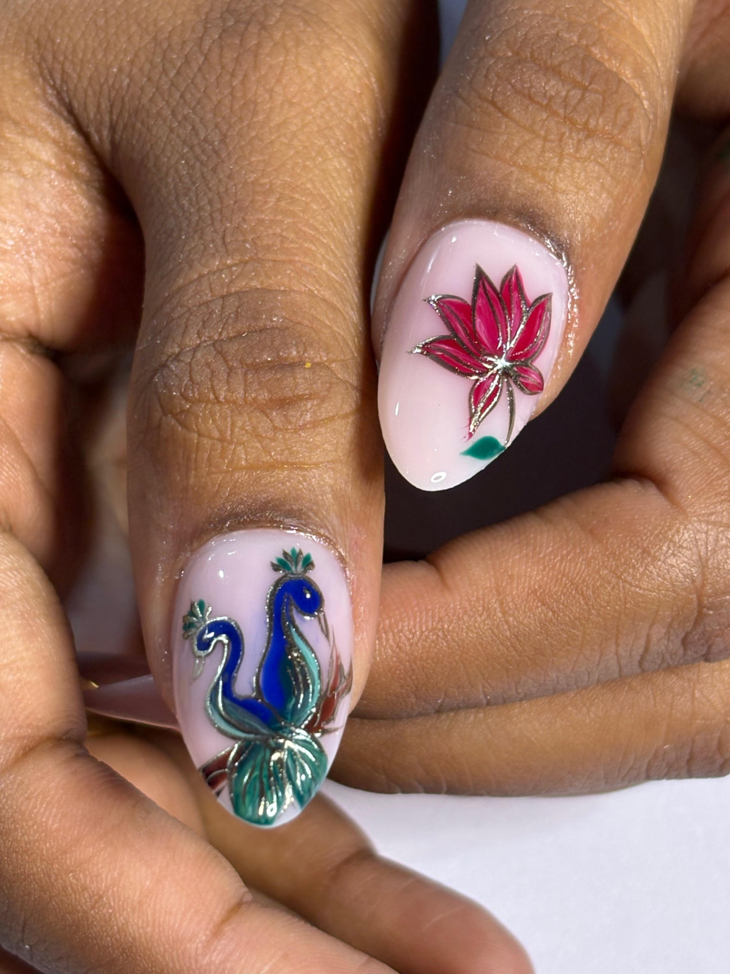 Sheer pink nails with hand-painted peacock and lotus in gold outline